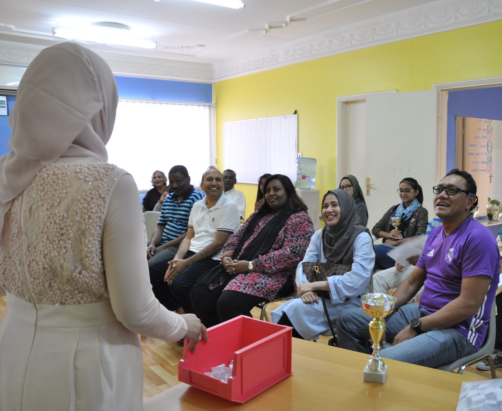 Parents taking part in the Parent Bee, trophy on the table
